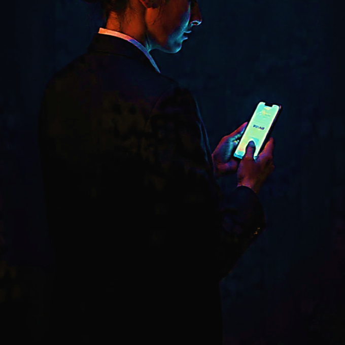 Ilustração estilo pintura a óleo mostrando uma pessoa conectada por fios luminosos a dispositivos, representando a tensão da hiperconectividade.